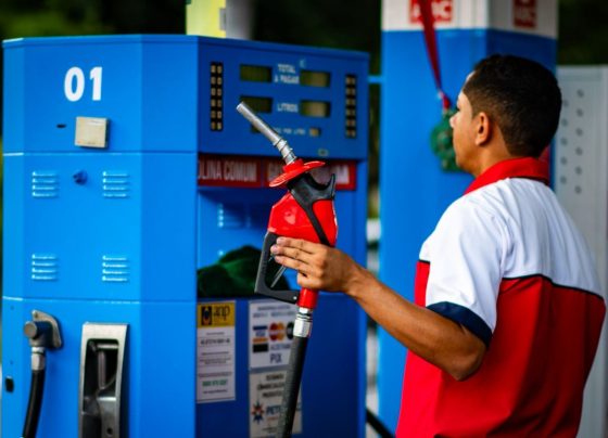 Foto colorida de trabalhador em posto de gasolina