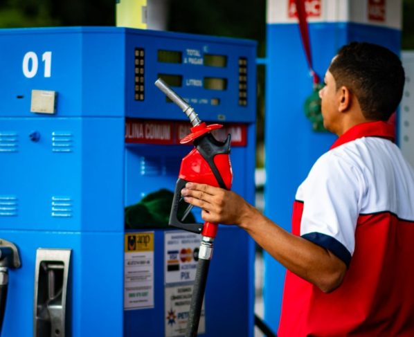 Foto colorida de trabalhador em posto de gasolina