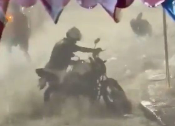 Foto colorida de motoqueiro em meio a alagamento no Rio - Metrópoles