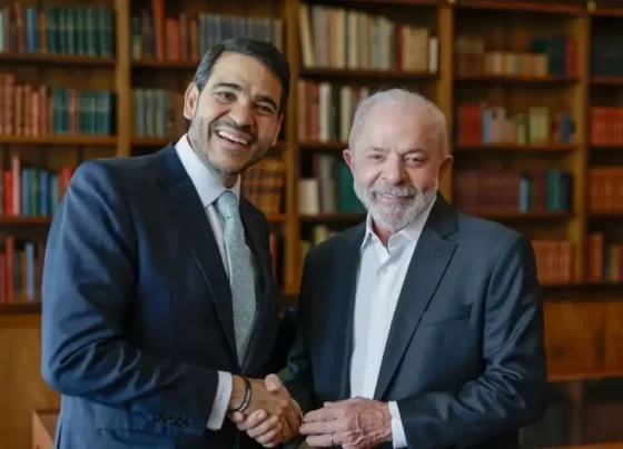 Dois homens sorridentes apertam as mãos