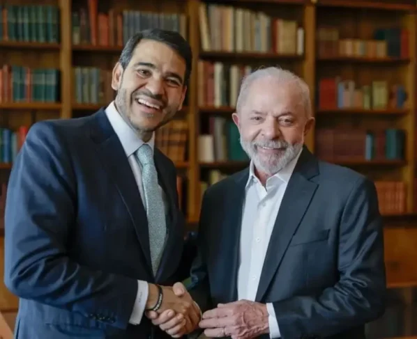 Dois homens sorridentes apertam as mãos