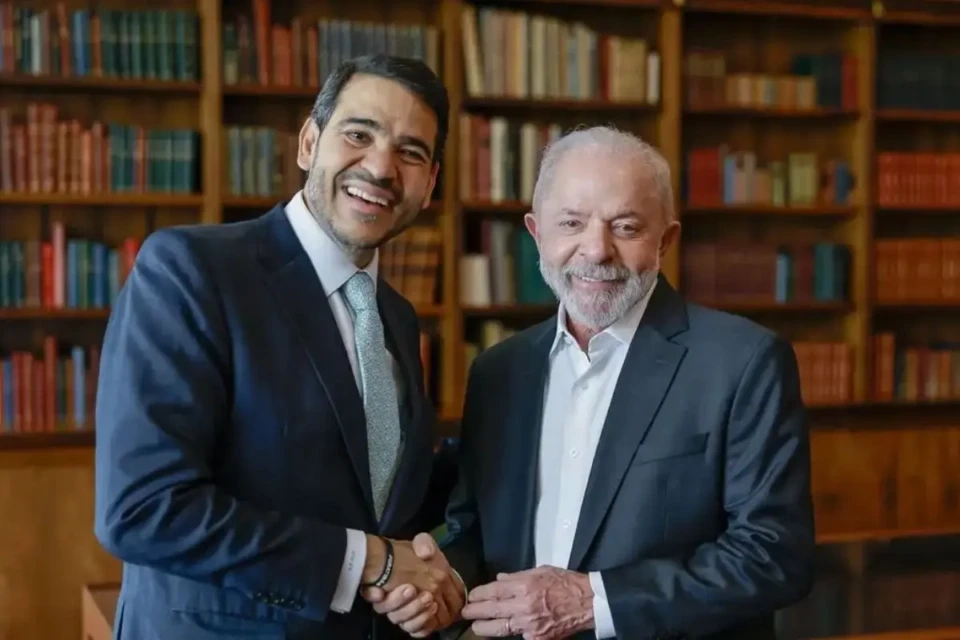 Dois homens sorridentes apertam as mãos