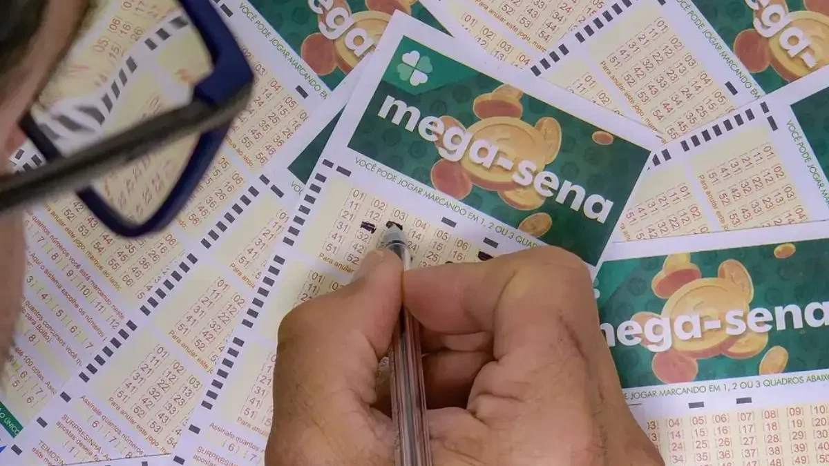 Mão preenchendo jogo da Mega-Sena